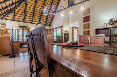 a dining room with a long wooden table and chairs at Kruger Park Lodge Unit No 521 with Private Pool in Hazyview
