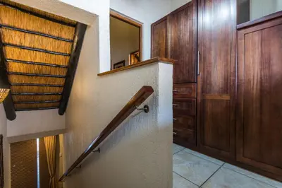 a hallway with a staircase and a wooden door at Kruger Park Lodge Unit No 521 with Private Pool in Hazyview