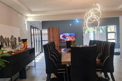 a dining room with a table and chairs at House of Bongekile 4 Bed Luxury Home in Malelane in Malelane