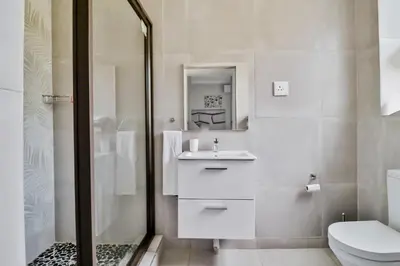 a bathroom with a toilet and a sink and a shower at House of Bongekile 4 Bed Luxury Home in Malelane in Malelane