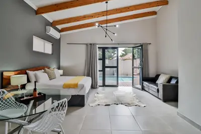 a bedroom with a bed and a living room at House of Bongekile 4 Bed Luxury Home in Malelane in Malelane