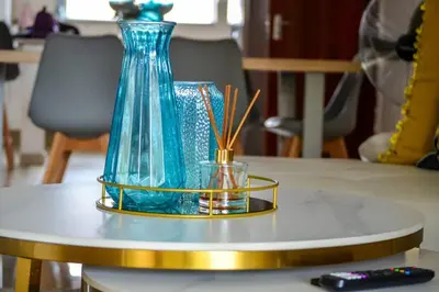 a blue glass vase sitting on top of a table at Peaceful gateaway - 2 bed apartment in Sunninghill with back-up power in Sandton