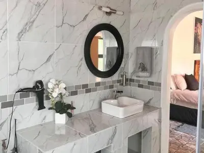 a bathroom with a sink and a mirror at Dream Inn in Marloth Park