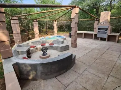 a patio with a fire pit and a grill at Dream Inn in Marloth Park