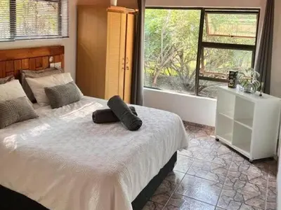 a bedroom with a bed with two pillows on it at Dream Inn in Marloth Park