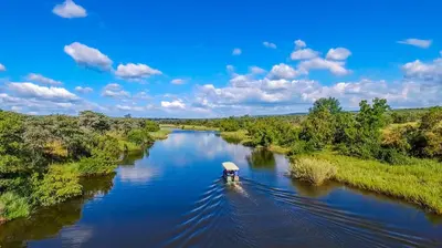 a small boat on a river in the middle at Royal Morubisi Founder's Lodge in Kaingo Private Game Reserve