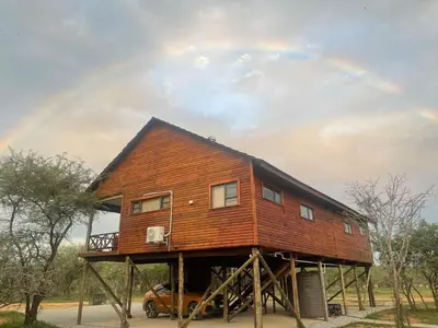 a house on wooden scaffolding with a car under it at Marloth Kruger View in Marloth Park