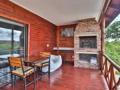 a porch with a table and a brick fireplace at Marloth Kruger View in Marloth Park