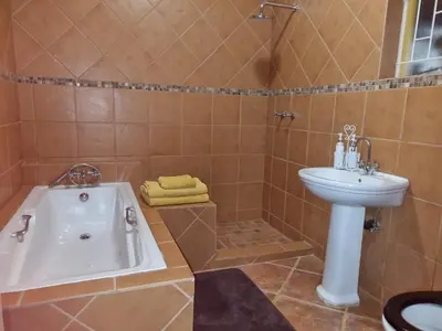 a bathroom with a tub and a sink at Pecan Nut Place in Dalmada AH