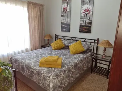a bedroom with a bed with yellow towels on it at Pecan Nut Place in Dalmada AH