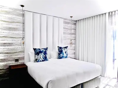 a bedroom with a large white bed with blue pillows at Panorama Boutique Guest House in Graskop