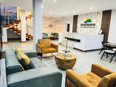 a lobby with a couch and chairs and a table at Panorama Boutique Guest House in Graskop