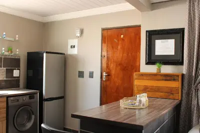 a kitchen with a refrigerator and a wooden counter top at The Villa 442 in Pretoria
