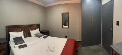 a bedroom with a large bed and a shower at The Villa 442 in Pretoria