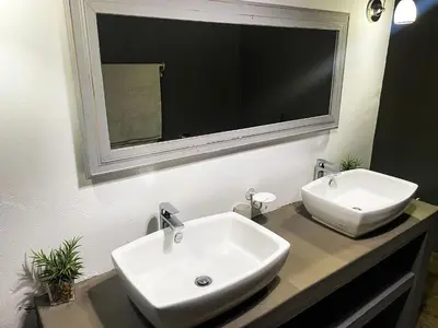 a bathroom with a white sink and a mirror at Ukuthula @ the Kruger in Marloth Park