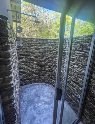 a glass door of a room with a stone wall at Ukuthula @ the Kruger in Marloth Park