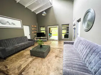 a living room with two couches and a tv at Ukuthula @ the Kruger in Marloth Park