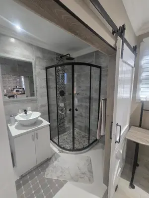 a bathroom with a shower and a sink at Country Cabin in Midrand