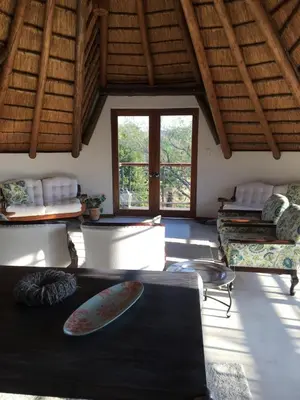 a living room with a surfboard on a table at Oak Tree Lodge, Beaulieu, Kyalami in Midrand