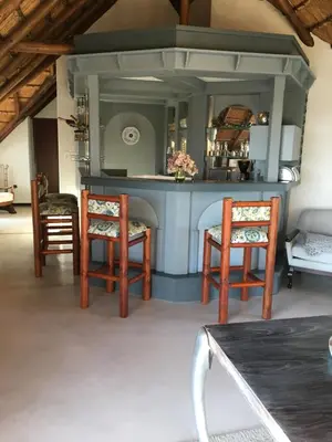 a kitchen with two chairs and a table at Oak Tree Lodge, Beaulieu, Kyalami in Midrand