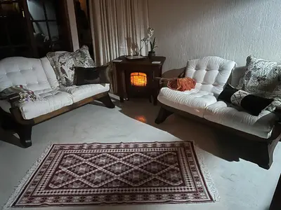 a living room with two white couches and a fireplace at Oak Tree Lodge, Beaulieu, Kyalami in Midrand