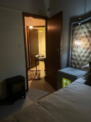 a bedroom with a bed and a hallway with a table at Oak Tree Lodge, Beaulieu, Kyalami in Midrand