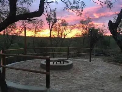 a sunset view from a park with a bench at Oryx Wilderness Game Lodge and Tented Camp in Rhenosterfontein