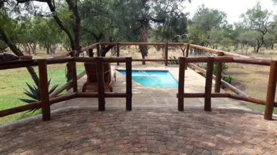 a wooden frame around a swimming pool with a fence at Oryx Wilderness Game Lodge and Tented Camp in Rhenosterfontein