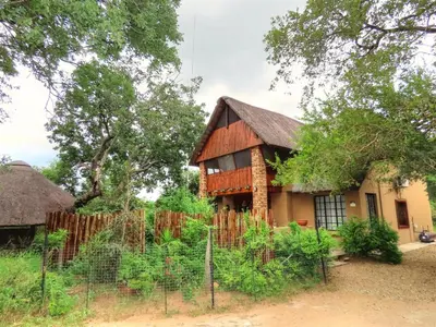 a house with a fence in front of it at Adventure Bush House II in Marloth Park