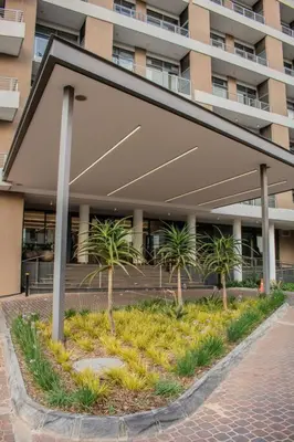 a large building with palm trees in front of it at Menlyn Maine Gem in Pretoria