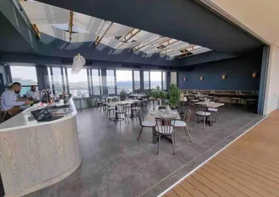 a dining room with tables and chairs and windows at Menlyn Maine Gem in Pretoria