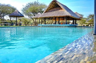 a swimming pool with a gazebo and blue water at Bradbury Game Lodge and Function Venue in Polokwane