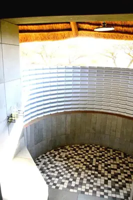 a bathroom with a fireplace with a tiled floor at Bradbury Game Lodge and Function Venue in Polokwane