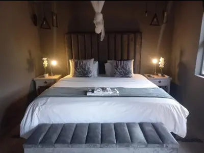 a bedroom with a large bed with two night stands at Bradbury Game Lodge and Function Venue in Polokwane