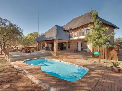 a house with a swimming pool in front of it at Luxurious 4 Bedroom Villa 94 in Mabula