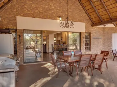 a dining room with a table and chairs at Luxurious 4 Bedroom Villa 94 in Mabula