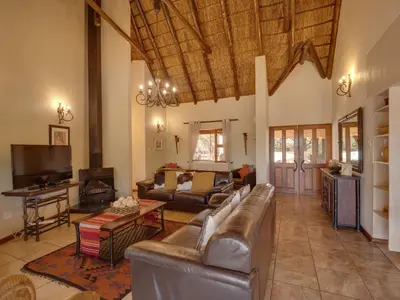 a living room with a couch and a tv at Luxurious 4 Bedroom Villa 94 in Mabula