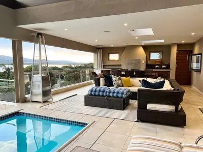 a living room with a couch and a swimming pool at The Windsor- Hartbeespoort Dam in Hartbeespoort