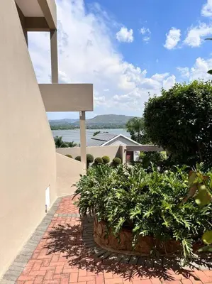 a brick walkway with potted plants next to a building at The Windsor- Hartbeespoort Dam in Hartbeespoort