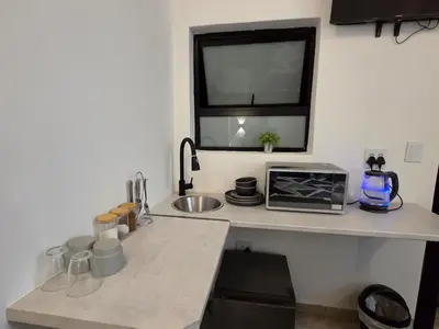 a kitchen with a counter with a sink and a window at East Park Inn in Polokwane