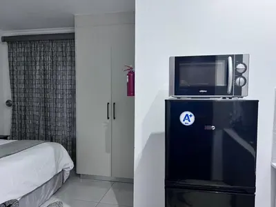 a bedroom with a bed and a tv on a cabinet at Beevap Guesthouse in Pretoria