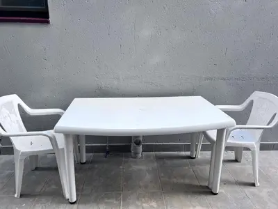 a white table and two chairs next to a wall at Beevap Guesthouse in Pretoria