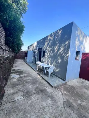 a building with a table and two benches next to it at Beevap Guesthouse in Pretoria
