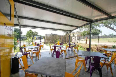 a group of tables and chairs on a patio at SleepOver Phabeni in Hazyview