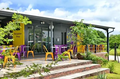 a patio with colorful chairs and tables in front of a building at SleepOver Phabeni in Hazyview