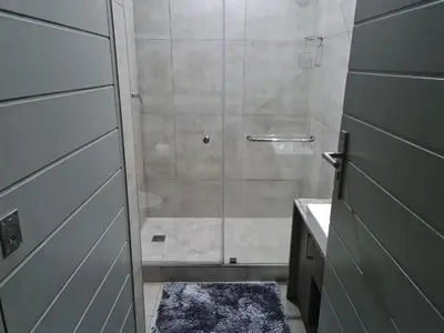 a shower with a glass door in a bathroom at Stunning City Living at Loftus in Pretoria