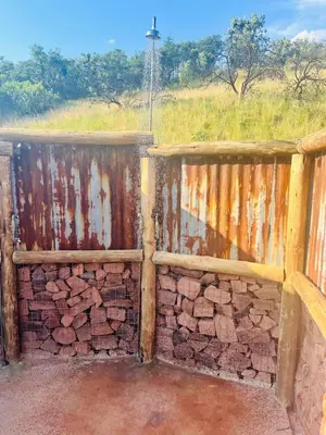 a wooden fence next to a brick wall at Rocky Road Mountain Lodge in Pretoria