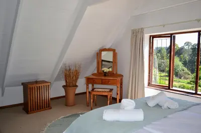 a bedroom with a bed and a desk and a mirror at Eagles Nest in Dullstroom
