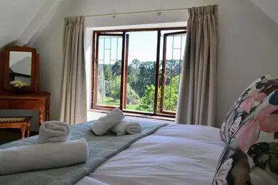 a bedroom with a bed and a large window at Eagles Nest in Dullstroom