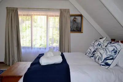 a bedroom with a large bed with blue and white sheets at Eagles Nest in Dullstroom